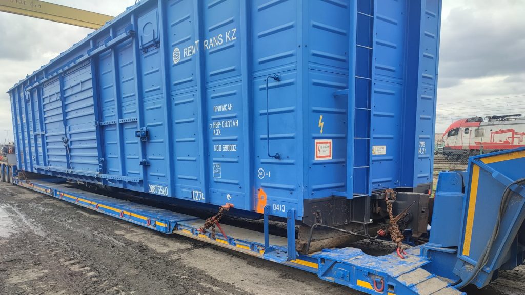 Niebieski kontener na platformie transportowej